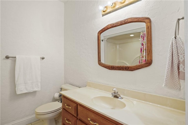 bathroom featuring tile patterned flooring, vanity, and toilet