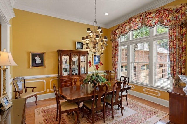 dining room with baseboards, crown molding, light wood finished floors, and an inviting chandelier