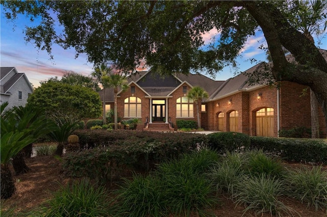 view of front of property with a garage and brick siding