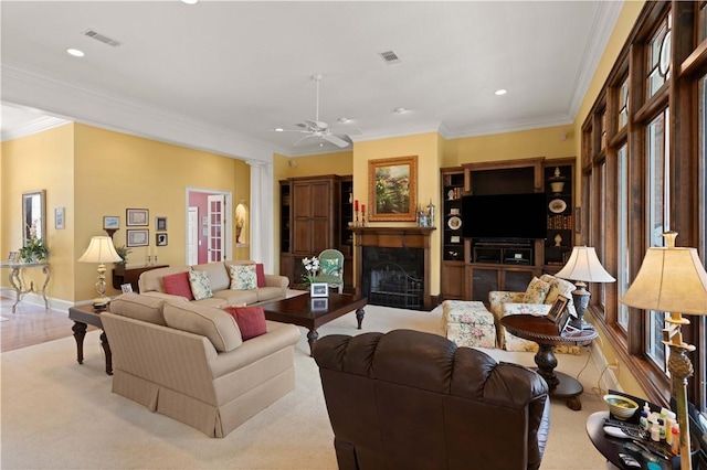 living area with a fireplace, decorative columns, and crown molding