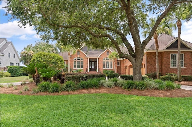 view of front of property with a front yard and brick siding