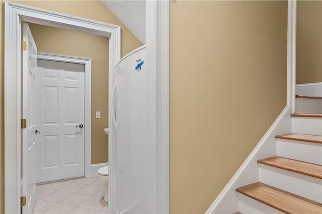 stairway with tile patterned floors