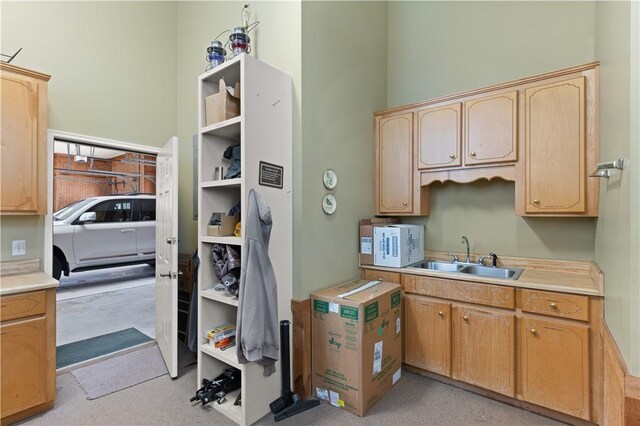 kitchen with white microwave, light brown cabinets, light countertops, and a sink