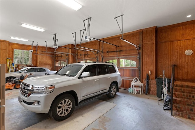 garage with a garage door opener and wood walls