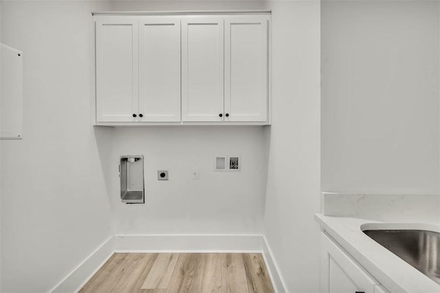 laundry room featuring electric dryer hookup, hookup for a washing machine, cabinets, and light hardwood / wood-style floors