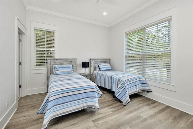 bedroom with light hardwood / wood-style floors and crown molding