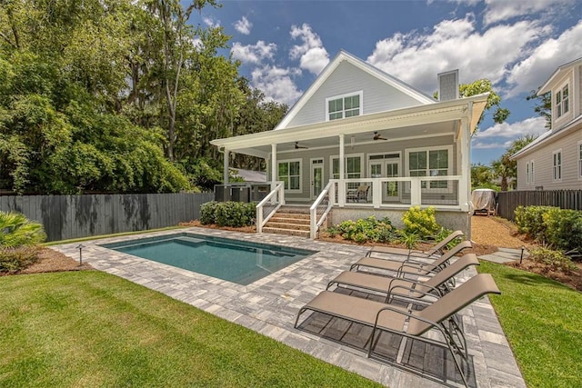 back of property featuring a yard, a fenced in pool, and ceiling fan