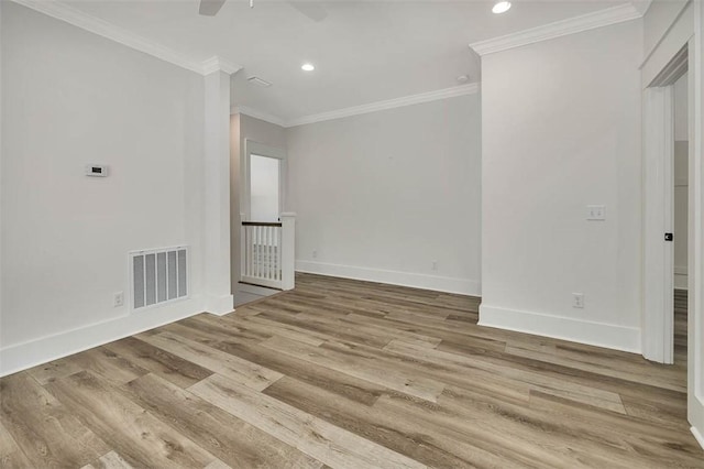 spare room with light wood-type flooring, ceiling fan, and crown molding