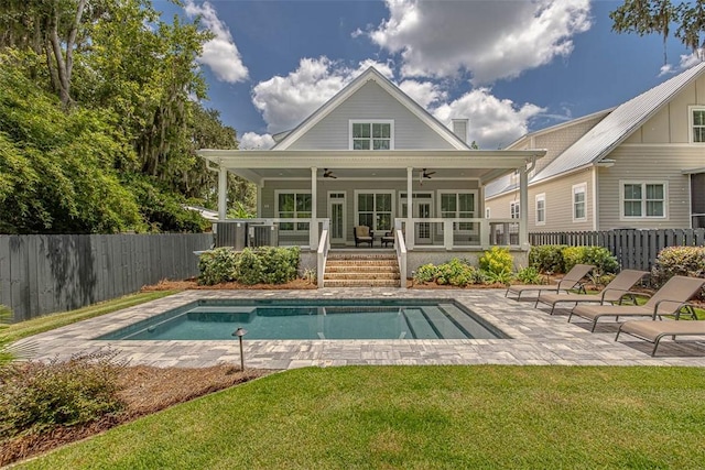 rear view of house featuring a swimming pool side deck, ceiling fan, and a lawn