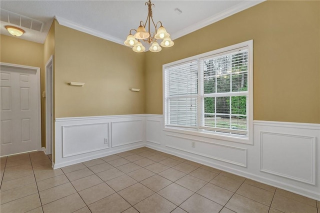 unfurnished dining area with a wainscoted wall, crown molding, visible vents, light tile patterned flooring, and a chandelier