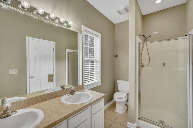 bathroom featuring a stall shower, tile patterned flooring, a sink, and toilet