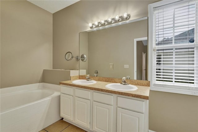 bathroom with double vanity, a bath, a sink, and tile patterned floors