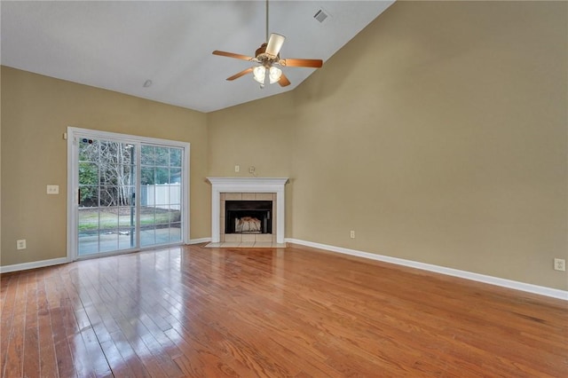 unfurnished living room featuring visible vents, light wood-style flooring, ceiling fan, a tile fireplace, and baseboards