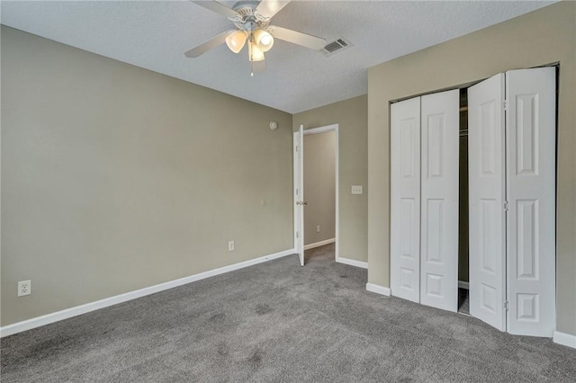 unfurnished bedroom with carpet floors, visible vents, ceiling fan, a textured ceiling, and baseboards