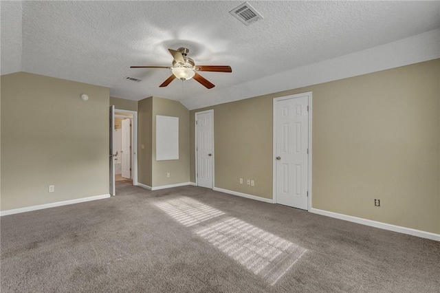 carpeted empty room featuring lofted ceiling, visible vents, and baseboards