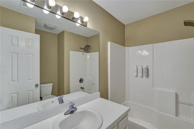 full bathroom featuring toilet, visible vents, a textured ceiling, and vanity