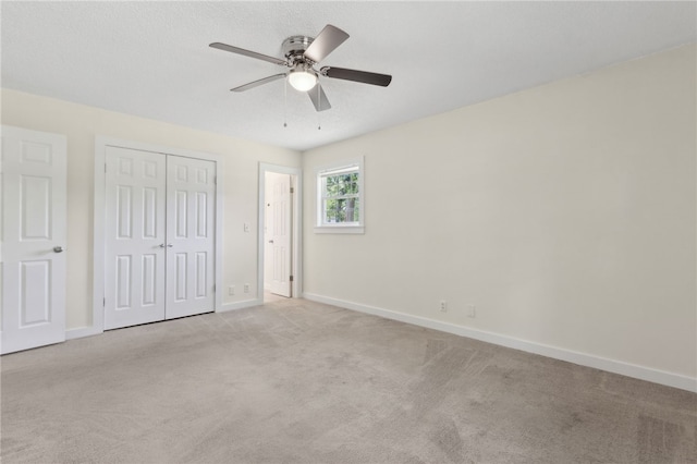 unfurnished bedroom with baseboards, a ceiling fan, carpet flooring, and a closet