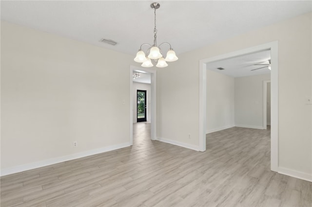 empty room featuring baseboards, ceiling fan with notable chandelier, visible vents, and light wood-type flooring