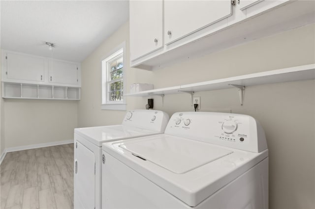 laundry room featuring washer and dryer, baseboards, and cabinet space