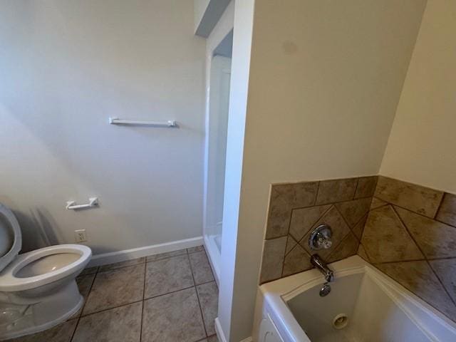 bathroom featuring tile patterned flooring, toilet, and a bath