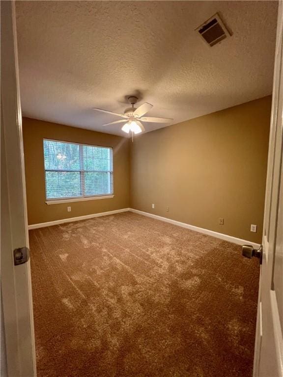 carpeted empty room featuring ceiling fan and a textured ceiling