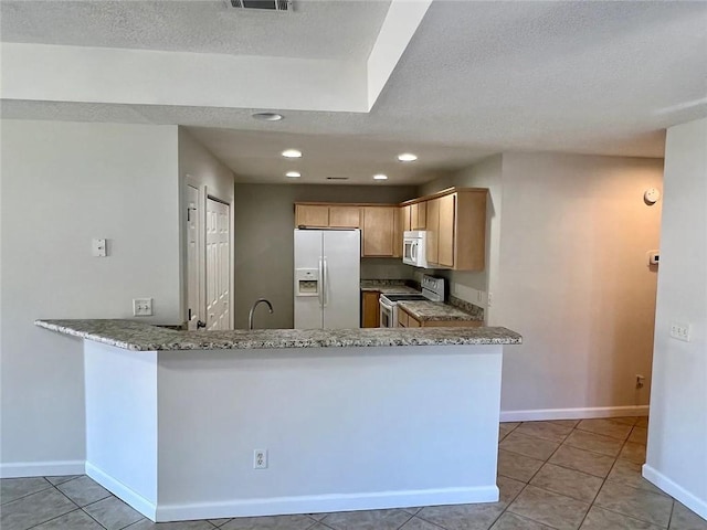 kitchen with light brown cabinets, white appliances, light stone countertops, light tile patterned floors, and kitchen peninsula