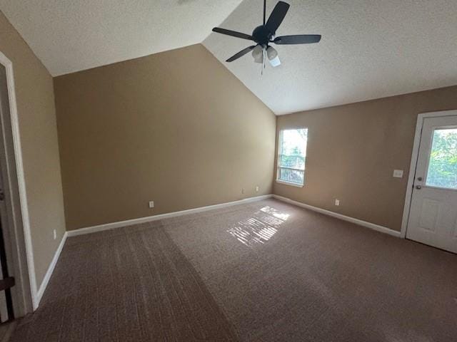 unfurnished living room with a healthy amount of sunlight, a textured ceiling, and vaulted ceiling