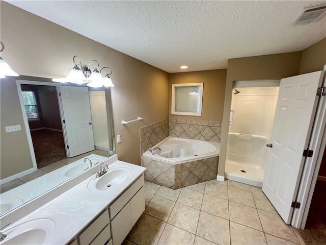 bathroom with tile patterned flooring, vanity, a textured ceiling, and plus walk in shower