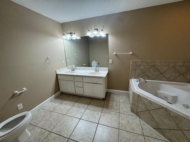 bathroom with tile patterned floors, vanity, a textured ceiling, tiled tub, and toilet