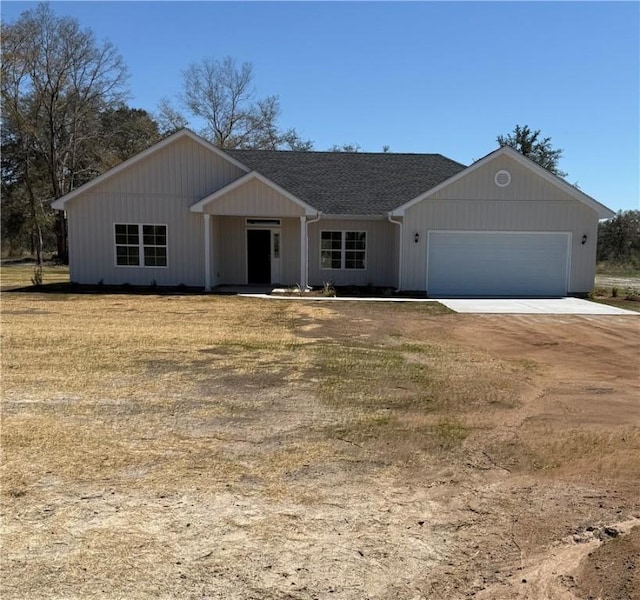 view of front of house with dirt driveway and a shingled roof