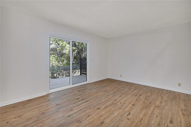 unfurnished bedroom featuring a walk in closet, ceiling fan, and dark wood-type flooring