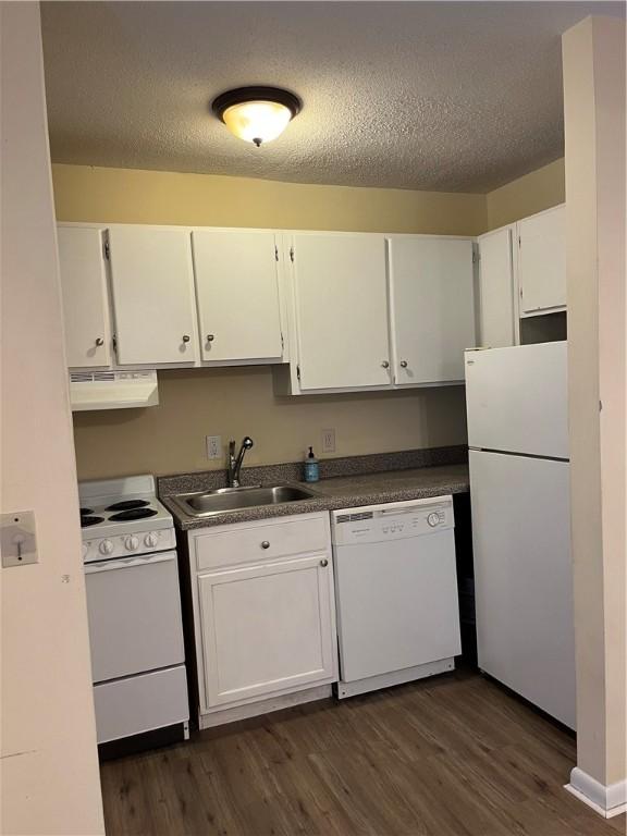 kitchen featuring white appliances, a textured ceiling, white cabinetry, and sink