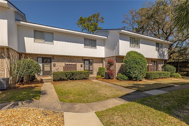 townhome / multi-family property featuring brick siding and a front lawn