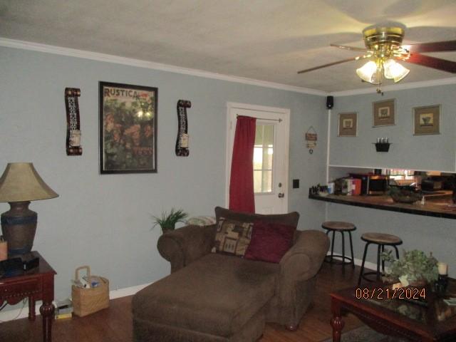 living room featuring ceiling fan, wood-type flooring, and ornamental molding