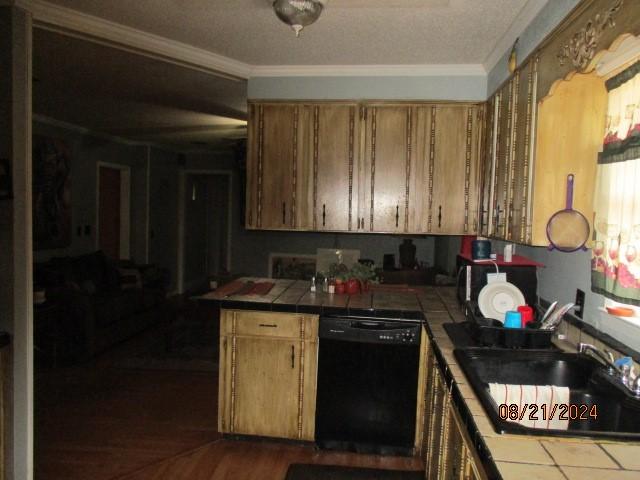 kitchen featuring tile counters, dishwasher, sink, dark hardwood / wood-style floors, and crown molding