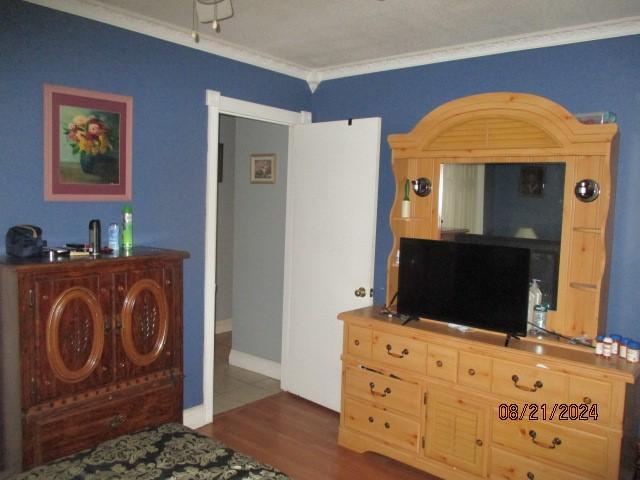 bedroom featuring crown molding and dark hardwood / wood-style flooring