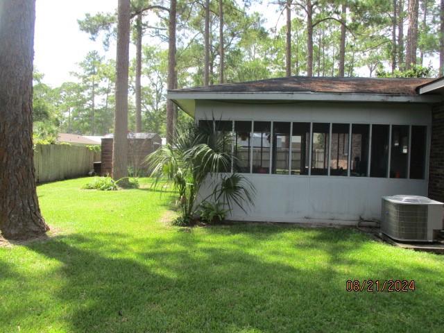 view of yard featuring a sunroom and central AC