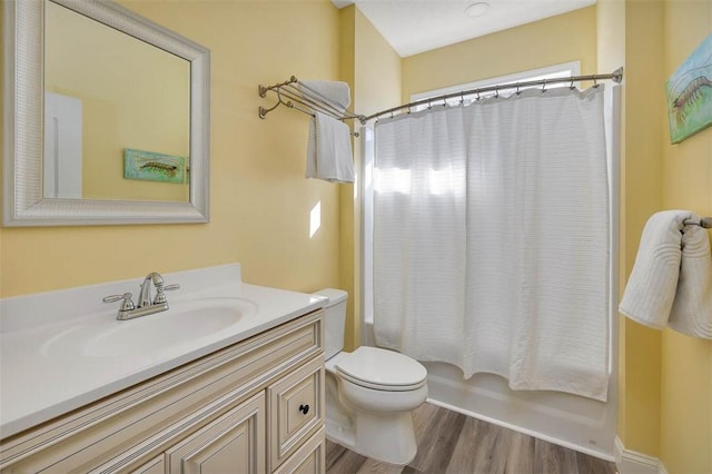 full bath featuring vanity, toilet, wood finished floors, and shower / bath combo with shower curtain