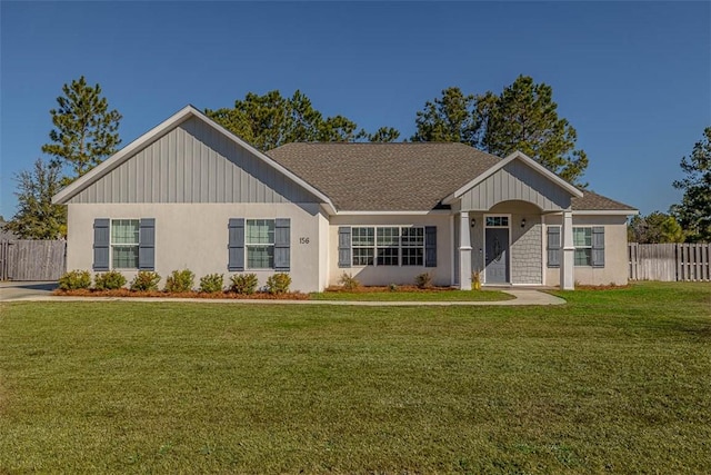 single story home featuring a shingled roof, a front lawn, and fence