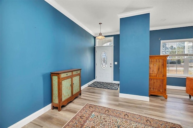 foyer featuring wood finished floors, baseboards, and ornamental molding