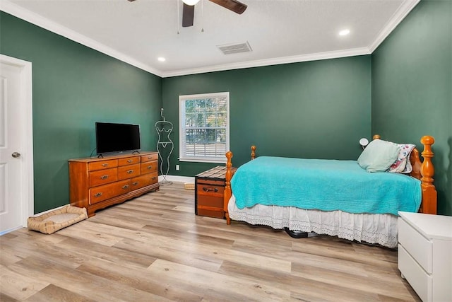 bedroom featuring visible vents, crown molding, baseboards, wood finished floors, and a ceiling fan