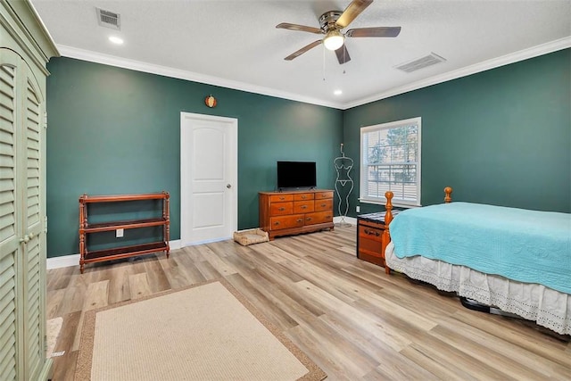 bedroom with visible vents, crown molding, and wood finished floors