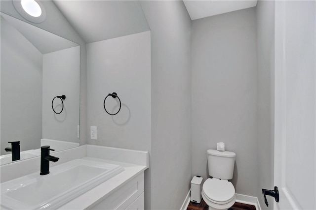 bathroom featuring vanity, vaulted ceiling, and toilet