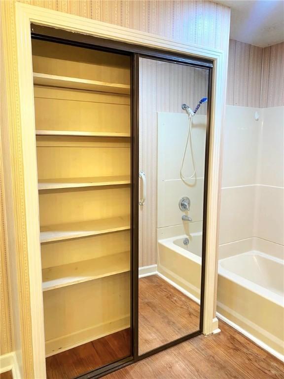 903 Atlantic Ave, Waycross, GA 31501 - bathroom featuring shower / bath combination and wood finished floors