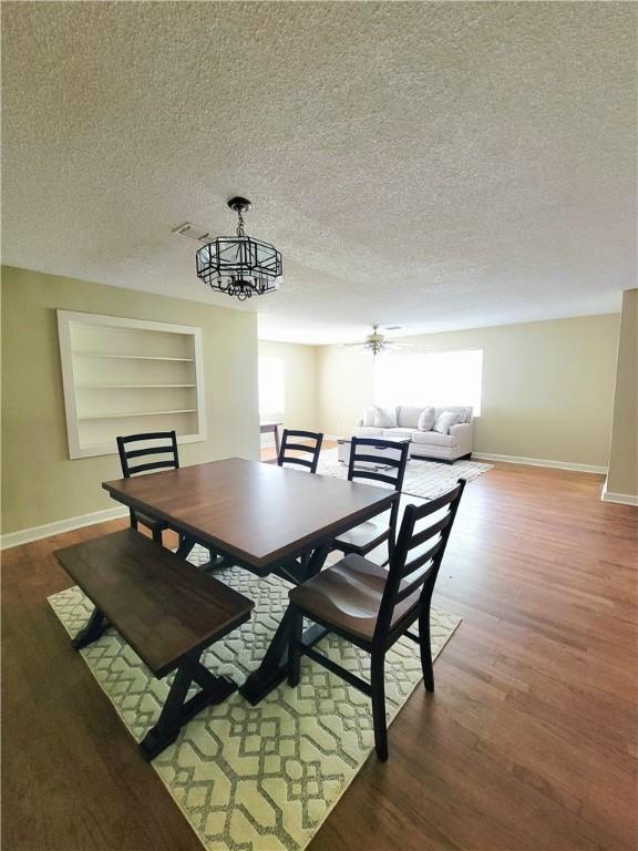903 Atlantic Ave, Waycross, GA 31501 - dining space featuring a textured ceiling, wood finished floors, built in shelves, and a chandelier