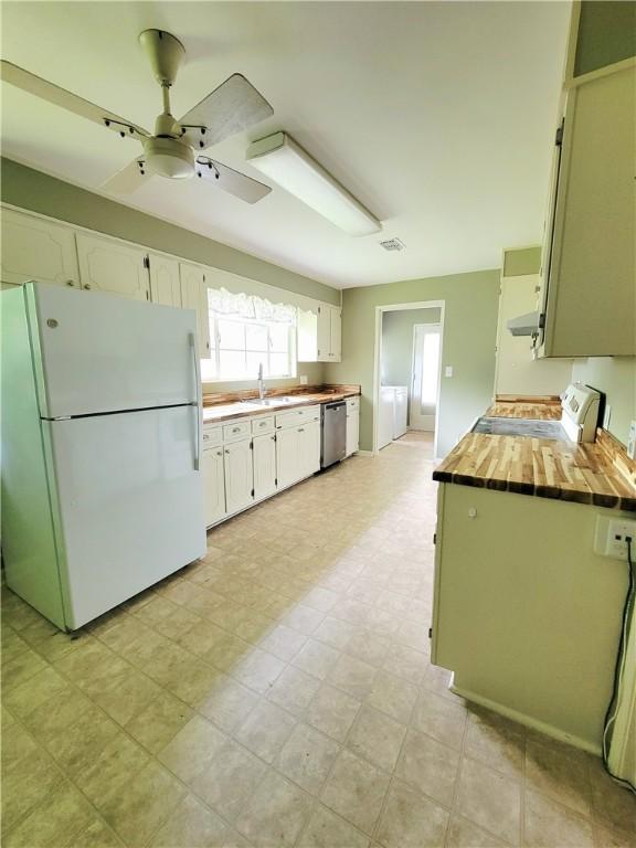 903 Atlantic Ave, Waycross, GA 31501 - kitchen featuring freestanding refrigerator, stainless steel dishwasher, ceiling fan, range, and wooden counters