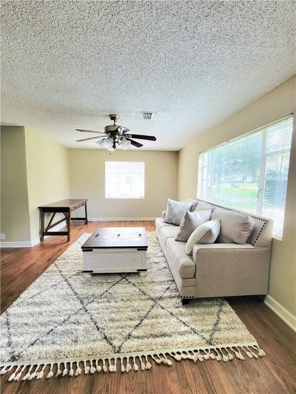 903 Atlantic Ave, Waycross, GA 31501 - living area with healthy amount of natural light, a ceiling fan, a textured ceiling, and wood finished floors