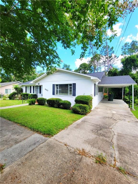 903 Atlantic Ave, Waycross, GA 31501 - single story home with concrete driveway, a front yard, a carport, and stucco siding
