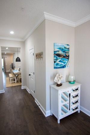 hallway with dark wood-type flooring and ornamental molding