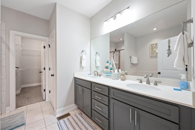 404 Mariners Cir, Saint Simons Island, GA 31522 - full bath with double vanity, a stall shower, a walk in closet, baseboards, and tile patterned floors